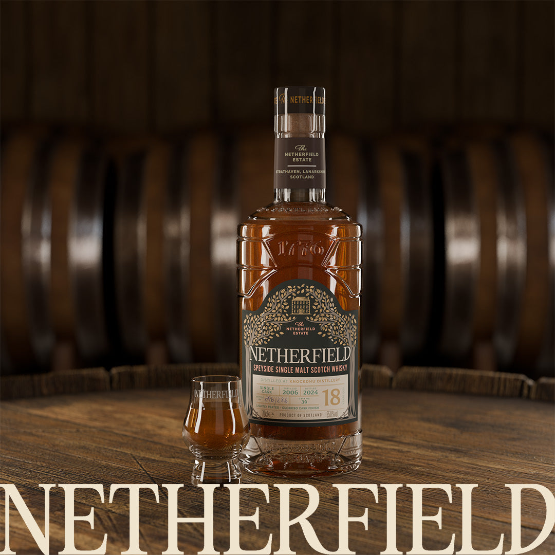 A Botttle of Netherfield Single Cask Knockdhu 18 years old with whisky glass on a barrel.